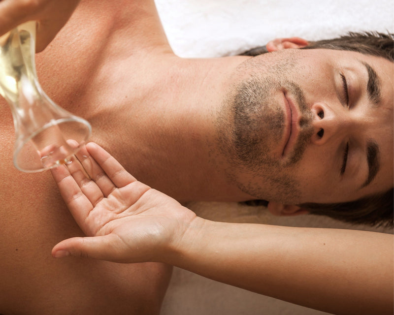 Entspannter Mann bei einer Massage mit Massageöl auf dem Oberkörper