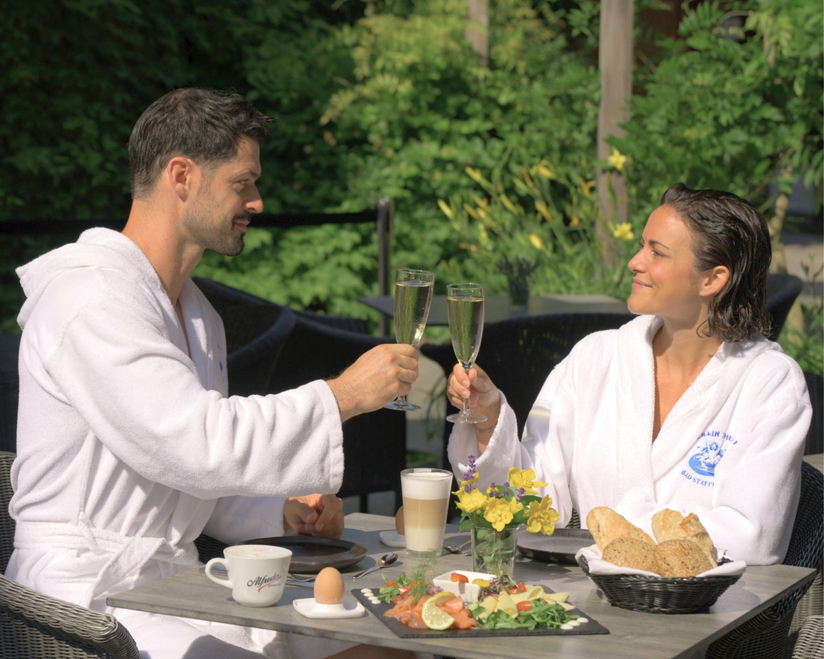 Paar genießt ein gemeinsames Frühstück im Bademantel